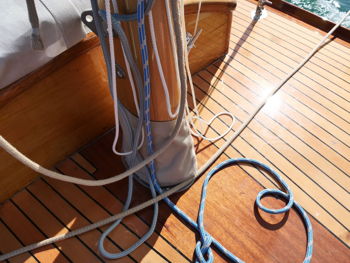 Aufgeschossene Leinen am Mastfuß auf dem Holzdeck.